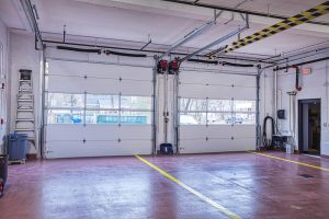Interior view of a modular building with large garage doors, showcasing the spacious layout suitable for temporary modular construction or permanent modular building applications.