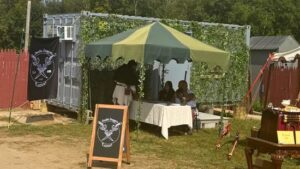Container Office covered in vines as a temporary retail and tattoo space for the Connecticut Renaissance Faire