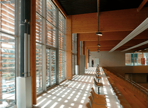 Interior of a triumph modular building featuring large windows, wooden beams, and a spacious layout, showcasing the benefits of modular construction for permanent and temporary modular buildings.