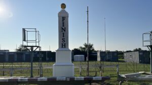 Suffolk Downs, Boston MA track finish line pole with Triumph trailer in the background