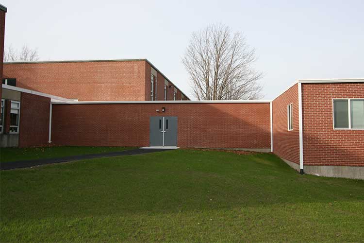 Exterior view of a triumph modular building showcasing modern modular construction with a green lawn and clear sky.