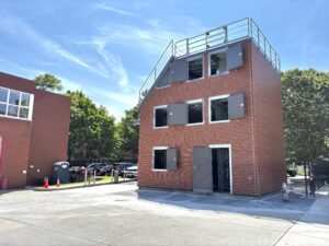Exterior image of Cambridge, MA for fire department training facility with the windows and doors open.