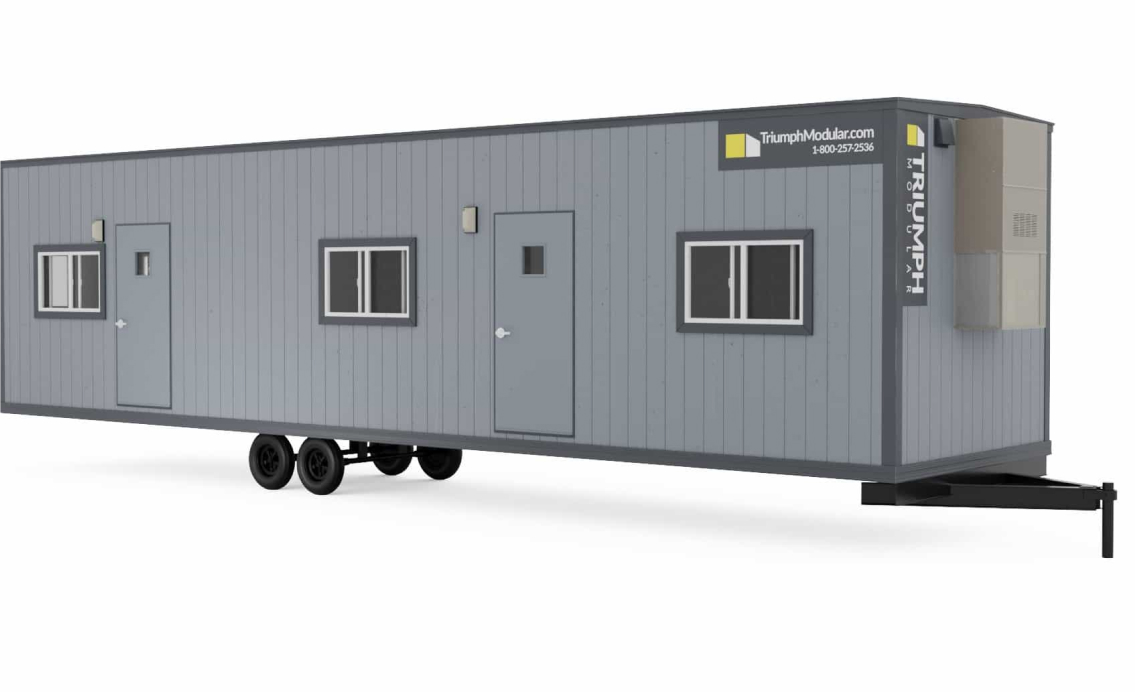 A temporary modular building from Triumph Modular, featuring a gray exterior, multiple windows, and a door, ideal for various construction site needs.