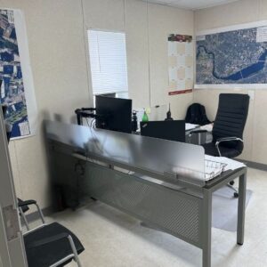 Interior Office Image with Business Office solution which includes a l-shaped desk, executive desk chair, and two stackable chairs.