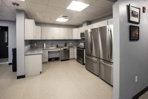 Modern kitchen in a triumph modular building showcasing stainless steel appliances and sleek cabinetry, highlighting the advantages of modular construction for both permanent and temporary modular buildings.