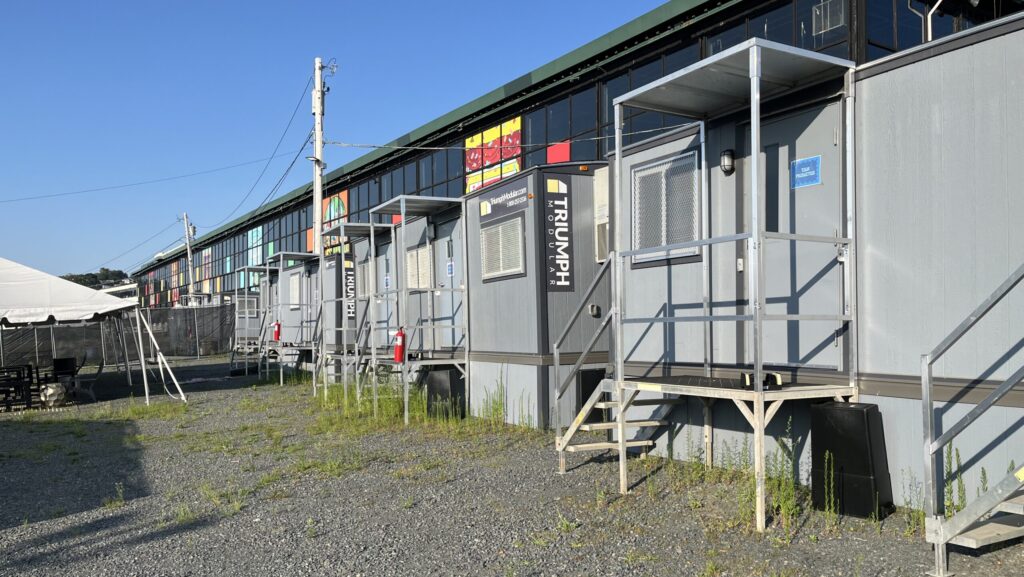 Row of Triumph Modular mobile offices lined up outside gate of Suffolk Downs, Boston MA